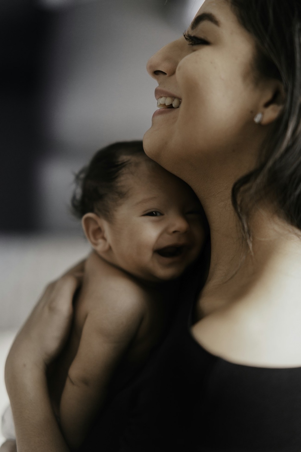 Mamá riendo con su bebé en brazos