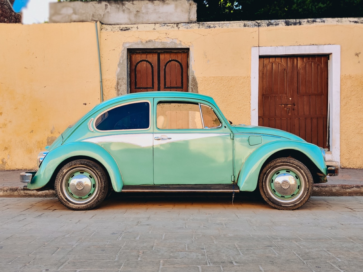 Vocho clásico estacionado frente a una casa mexicana